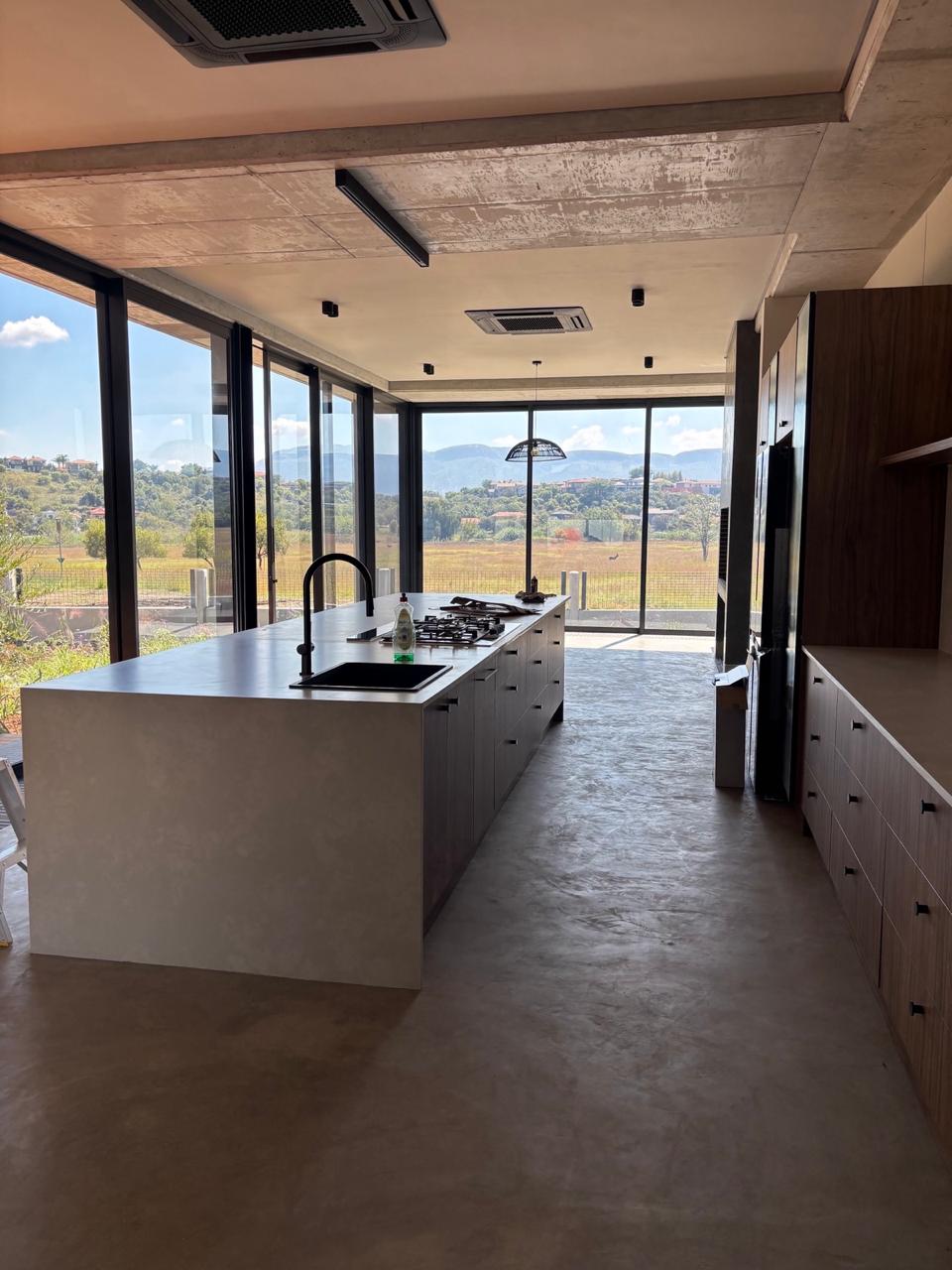 High-end kitchen interior with concrete ceilings and panoramic views