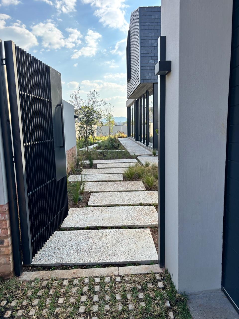 Exposed aggregate walkway leading through landscaped gardens
